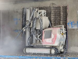 Aqua Cutter performing hydrodemolition of an interior wall on the 13th story of a building which was being demolished.