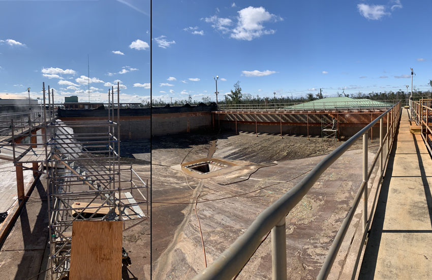 A large open industrial tank with scaffolding, railings, hoses, and stained metal surfaces under a blue sky.